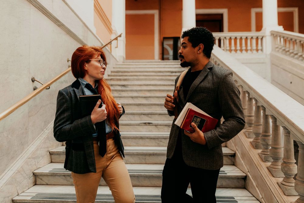 Estudante acompanhando as aulas pelo notebook, com um livro aberto ao lado